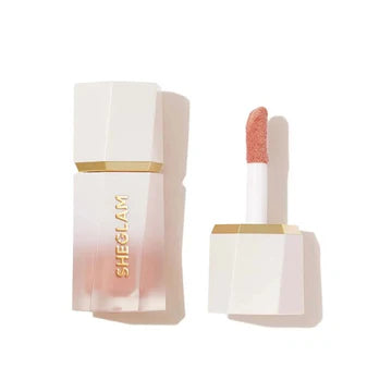 Close-up of SHEGLAM Glow Bloom Liquid Highlighter packaging showing a sleek glass bottle with a dropper applicator and silver cap. The minimalist design features the product name in clean typography against a clear background, emphasizing its dewy, luminous formula