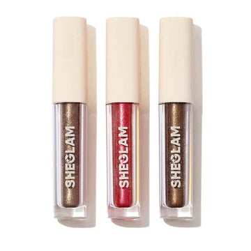 SHEGLAM Starry Wish Liquid Eyeshadow Trio in ‘Spaced Out,’ with repeated brand mark ‘SHECIAM’ on packaging. The sleek tube design suggests a metallic or glittery formula, ideal for celestial-inspired eye looks
