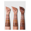 Swatches of SHEGLAM Sun Sculpt Liquid Contour applied on three arm models with light, medium, and deep skin tones. Each swatch shows the warm-toned contour shade blended out for a natural shadow effect, demonstrating its adaptability across different complexions