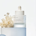 Skincare dropper bottle with text on a light blue background