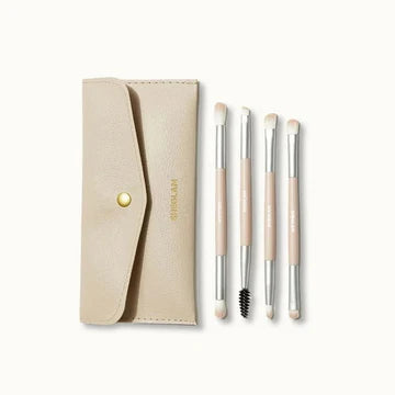 Sheglam Face Essentials Brush Set displayed in a sleek pouch or carrying bag, showcasing three makeup brushes: a flat foundation brush, a pointed concealer brush, and a tapered highlighter brush. The packaging is minimalist and practical for travel or storage