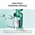 Green ampoule bottle with droplets on a light blue background